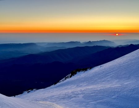 Sunrise Ascent – Experience a magical sunrise during the early morning summit push, illuminating the mountains in golden light.
